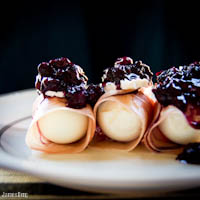 Prosciutto wrapped eggs with brie and a blueberry, Zinfandel, caper sauce